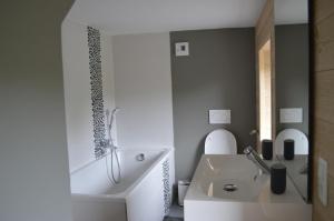 biała łazienka z umywalką i wanną w obiekcie la tourelle d’Achille leontine w mieście Rochefort