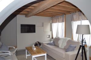 een woonkamer met een witte bank en een tafel bij la tourelle d’Achille leontine in Rochefort