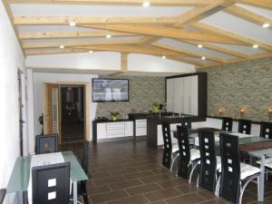 a dining room with tables and chairs and a kitchen at Ferienwohnungen Kaiser in Gallizien
