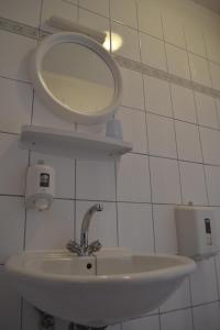 ein Bad mit einem Waschbecken und einem Wandspiegel in der Unterkunft Apartments Nanini in Prvić Luka