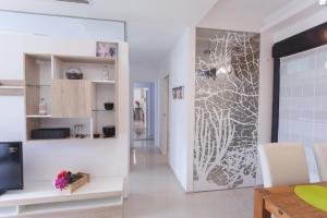 a living room with a wall mural of a plant at Apartamento Postman in Arenales del Sol