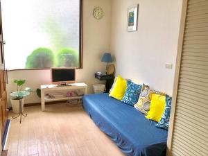 a living room with a blue couch with yellow pillows at 2-8-9 Jusohommachi - House / Vacation STAY 1677 in Osaka