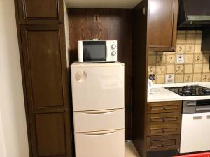 a kitchen with a microwave on top of a refrigerator at 2-8-9 Jusohommachi - House / Vacation STAY 1677 in Osaka