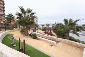 a resort with a park with a playground and palm trees at Apartamento Postman in Arenales del Sol