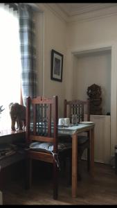stół jadalny z 2 krzesłami i stołem oraz stół i szezlong w obiekcie Jacobite Rose w mieście Inverness