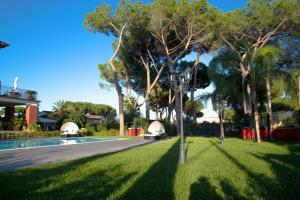 Selcetta的住宿－Relais Villa Italia，一个带游泳池、树木和街灯的庭院