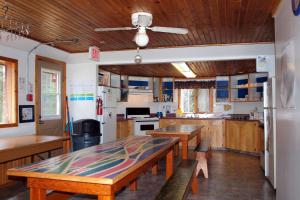 una cocina con armarios de madera y una mesa con bancos. en HI Castle Mountain - Hostel, en Castle Junction