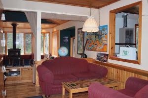 sala de estar con sofá rojo y mesa en HI Castle Mountain - Hostel, en Castle Junction