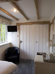 a bedroom with a bed and a desk and a chair at Random Hall in Slinfold