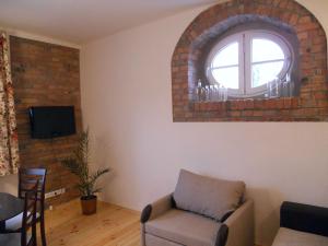 a living room with a couch and a window at Apartament Katowice - Nikiszowiec in Katowice