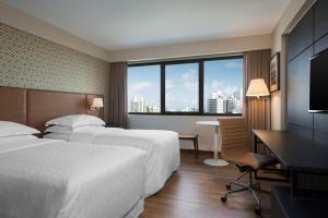 サルバドールにあるWish Hotel da Bahiaのベッド2台とデスクが備わるホテルルームです。