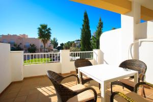 a patio with a table and chairs on a balcony at AT Almoraide Rooms Suites in Nerja