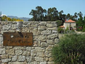 Una pared de piedra con un cartel que lee alma chica en Quinta da Alma Cheia, en Ninho do Açor