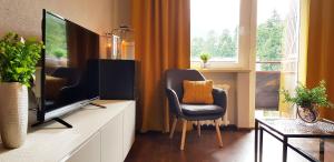 un salon avec une télévision et une chaise dans l'établissement Apartament Rodzinny, à Kościelisko