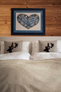 a heart picture above two beds in a bedroom at FIORI Dolomites Experience Hotel in San Vito di Cadore