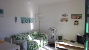 sala de estar con sofá y ventilador en Puerta Del Sol, en Caleta de Fuste
