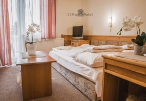 ein Hotelzimmer mit einem großen Bett und einem Schreibtisch in der Unterkunft Cifra Motel in Kecskemét