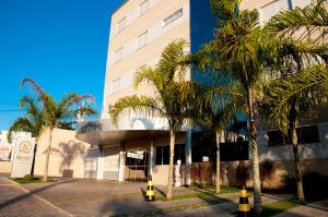 a building with palm trees in front of it at Hotel Roari in Cuiabá