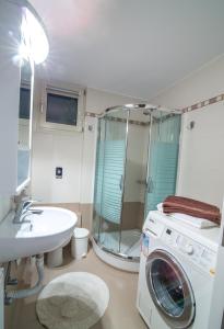 Un baño con lavadora y lavabo. en Luxury Villa Marilena, en Epáno Váthia