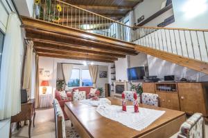 sala de estar con mesa y sillas y escalera en Luxury Villa Marilena, en Epáno Váthia