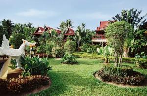 a garden in front of a resort with a chicken statue at Ban Kaew Villas in Bophut 