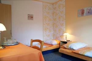 a hotel room with two beds and two tables at ABEN & HANA penzion in Modřice