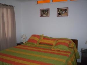 a bedroom with a bed and two pictures on the wall at cabañas sector peñuelas in Coquimbo