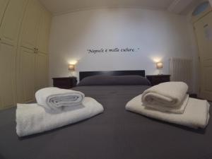 a bedroom with two beds with towels on them at Palazzo Rota Guesthouse in Naples