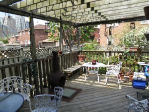 una terraza de madera con mesa y sillas. en All Seasons Bed & Breakfast, en Mississauga