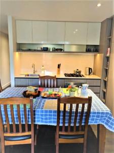 メルボルンにあるCamberwell Burke Road Apartmentのキッチン(青いチェッカー付きテーブルクロス付)