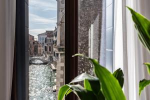 uma janela com vista para um canal em Palazzo Vendramin Costa em Veneza