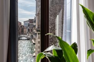 a window with a view of a canal at Palazzo Vendramin Costa in Venice