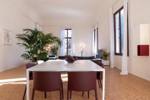 a dining room table and chairs in a room at Palazzo Vendramin Costa in Venice