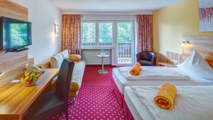 een hotelkamer met 2 bedden en een bureau bij Hotel Christel in Heimbuchenthal