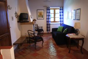 a living room with a couch and a tv at Agriturismo Villa Opera in Volterra