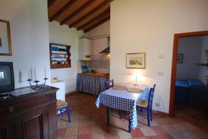 a living room with a table and a kitchen at Agriturismo Villa Opera in Volterra
