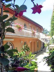 un edificio con un balcón blanco con flores. en ABEN & HANA penzion, en Modřice