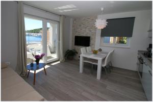 a living room with a table and a dining room at Apartments Silver Beauty in Rogoznica