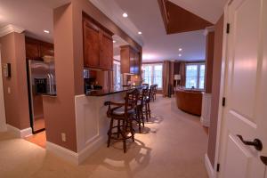a kitchen with a bar with stools at The Village Condo in Greensboro