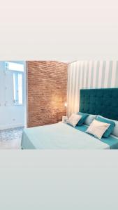バレンシアにあるApartamento Frederick “Centrico y con Clase”のベッドルーム1室(大型ベッド1台、青いヘッドボード付)
