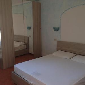 - une petite chambre avec un lit et un miroir dans l'établissement Sardinia Beach Apartments, à Aglientu
