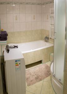 La salle de bains est pourvue d'une baignoire et d'une baignoire blanche. dans l'établissement Agroturystyka Lolkowo, à Srokowo