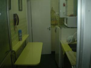 una pequeña cocina con mesa amarilla y microondas en Depto. 2 ambientes en Mar del Plata