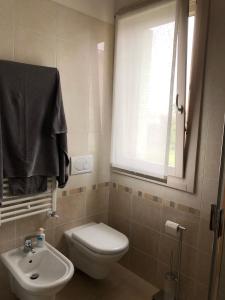 a bathroom with a toilet and a sink and a window at La stanza di Cesare in Treviso