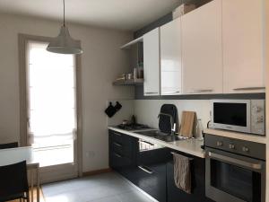 a kitchen with white cabinets and a stove top oven at La stanza di Cesare in Treviso +7 photos