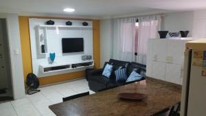 a living room with a couch and a television at Ótimo apartamento com wi-fi gratuito in Guarapari