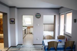 a dining room with a table and a bedroom at Apartmani Janjic in Banja Luka