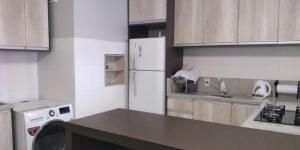 a kitchen with a white refrigerator and wooden cabinets at Apto prox. BR470 in Bento Gonçalves