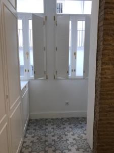 バレンシアにあるApartamento Frederick “Centrico y con Clase”の白いキャビネットと窓が備わる白い部屋