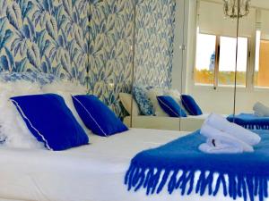 1 dormitorio con 1 cama con almohadas azules y blancas en Málaga Center Beach, en Málaga